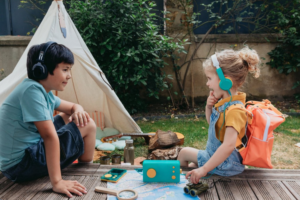 frère et soeur qui écoutent Lunii Ma fabrique à histoires et le baladeur flam pur développer leur imagination lors des trajets en voiture, avion et train.